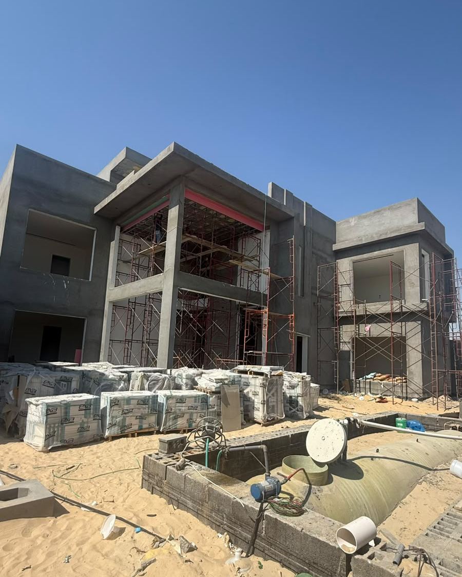 Khalaf Villa before: concrete shell with building materials on sand